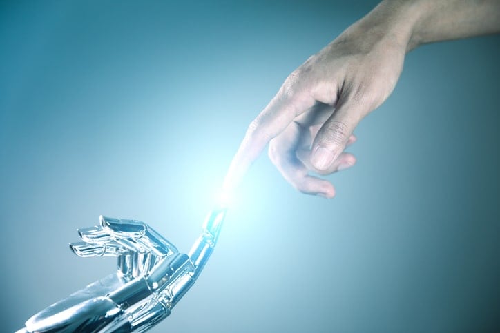 human and robot hand connecting